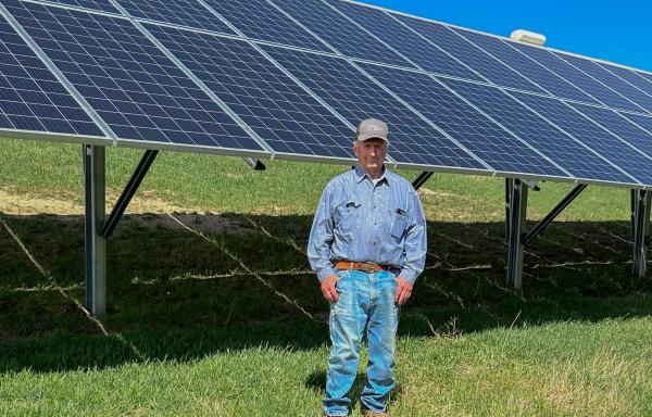 Richard Smith stands next to his solar array on his farm in Morris, Minnesota. 
